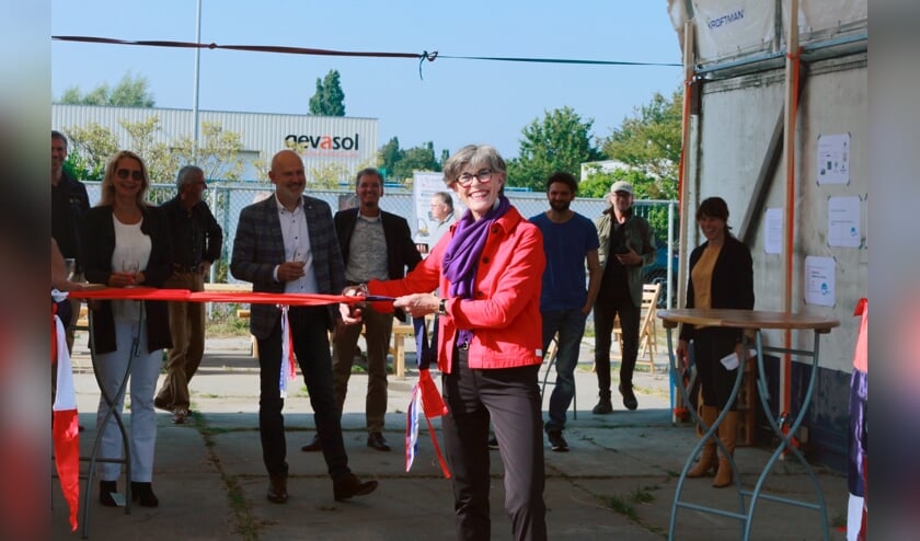 <p>Wethouder Heleen Hooij knipt een lintje door, gemaakt van oud textiel. | Foto: Lisa de Blok.</p>