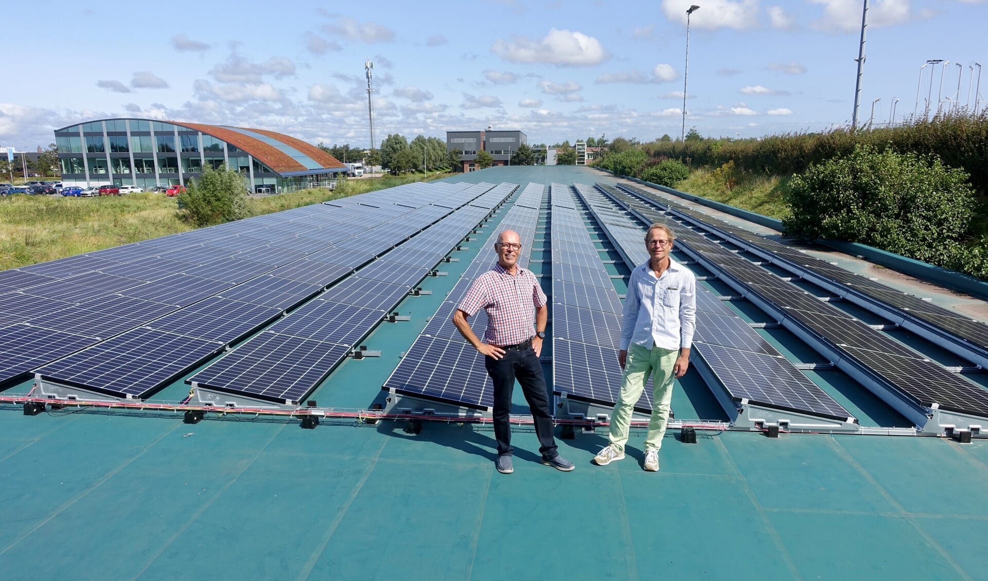 Bestuursleden Loek van Driel en Patrick Wijngaard van de Katwijkse Energie Coöperatie op het dak van Schietsportvereniging Katwijk op sportpark de Krom. Achteraan op het dak komen de 500 à 600 zonnepanelen van ‘Buurtstroom Katwijk 1’. | Foto: pr