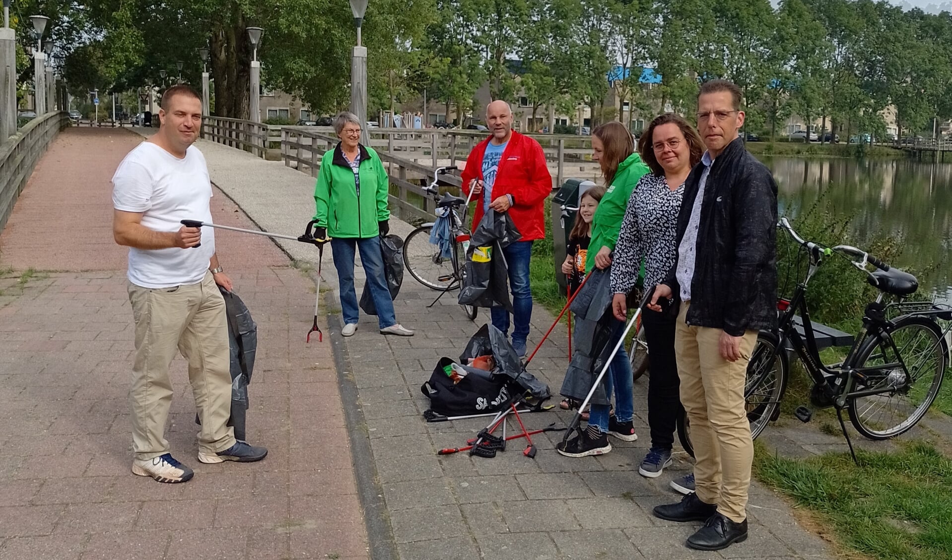 De gemeenteraadsleden Olaf McDaniel (PvdA, midden) en Marlies van Beek (GroenLinks, tweede van rechts) maken deel uit van de gezamenlijke schoonmaakploeg. | Foto: PR