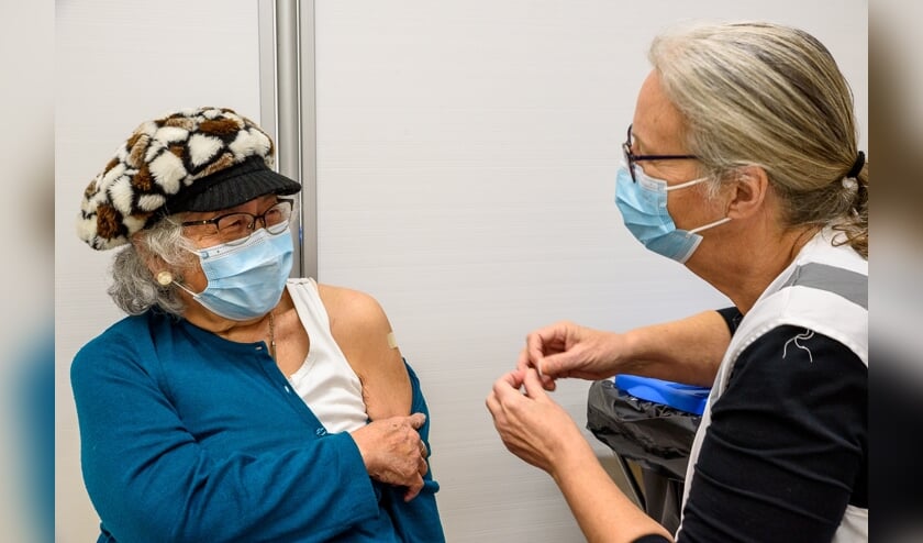 Een dame heeft net een boosterprik gekregen op de maandag geopende vaccinatielocatie in Leiderdorp.  