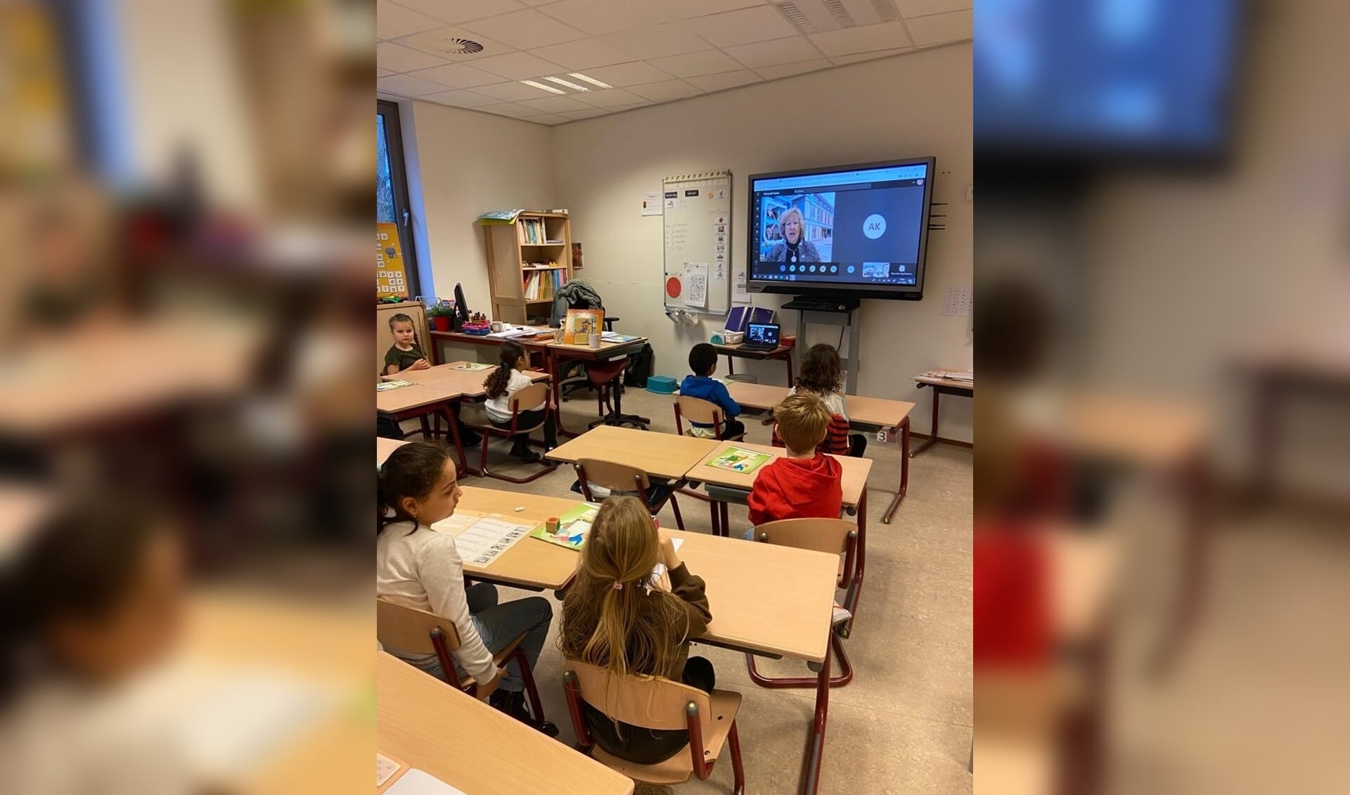 De kinderen van de Prins Willem-Alexanderschool luisteren naar burgemeester Driessen die via Teams het Prentenboek van het Jaar 'Maar eerst ving ik nog een monster' voorleest. 