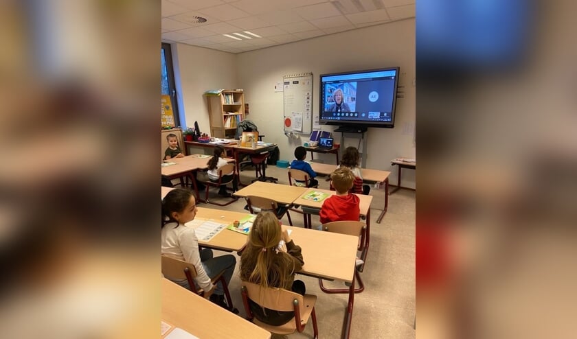 <p>De kinderen van de Prins Willem-Alexanderschool luisteren naar burgemeester Driessen die via Teams het Prentenboek van het Jaar &#39;Maar eerst ving ik nog een monster&#39; voorleest. </p>  
