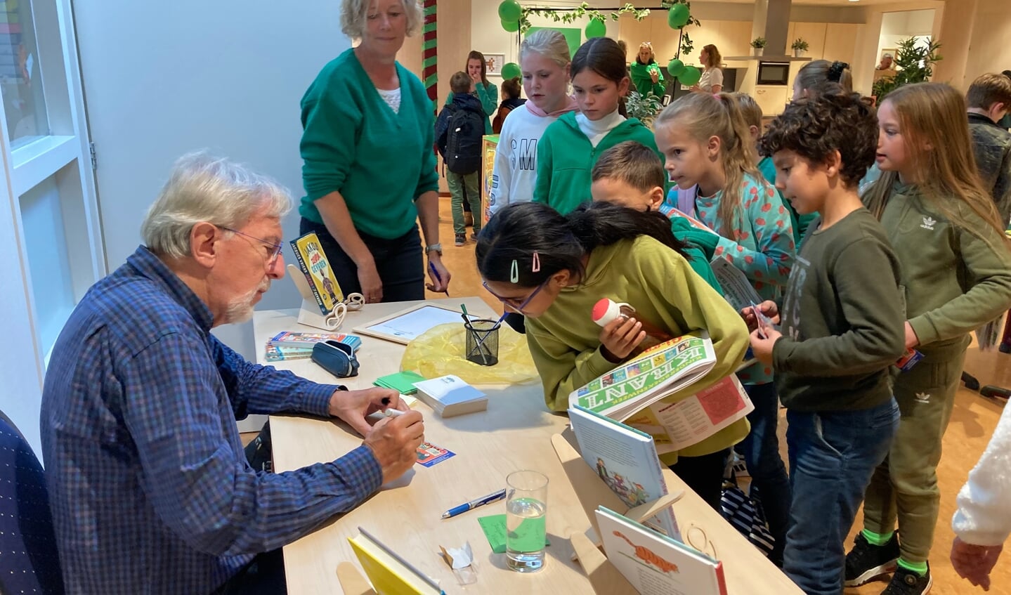 Kinderen van de Regenboog laten hun pas gekochte boeken signeren door schrijver Jacques Vriens.