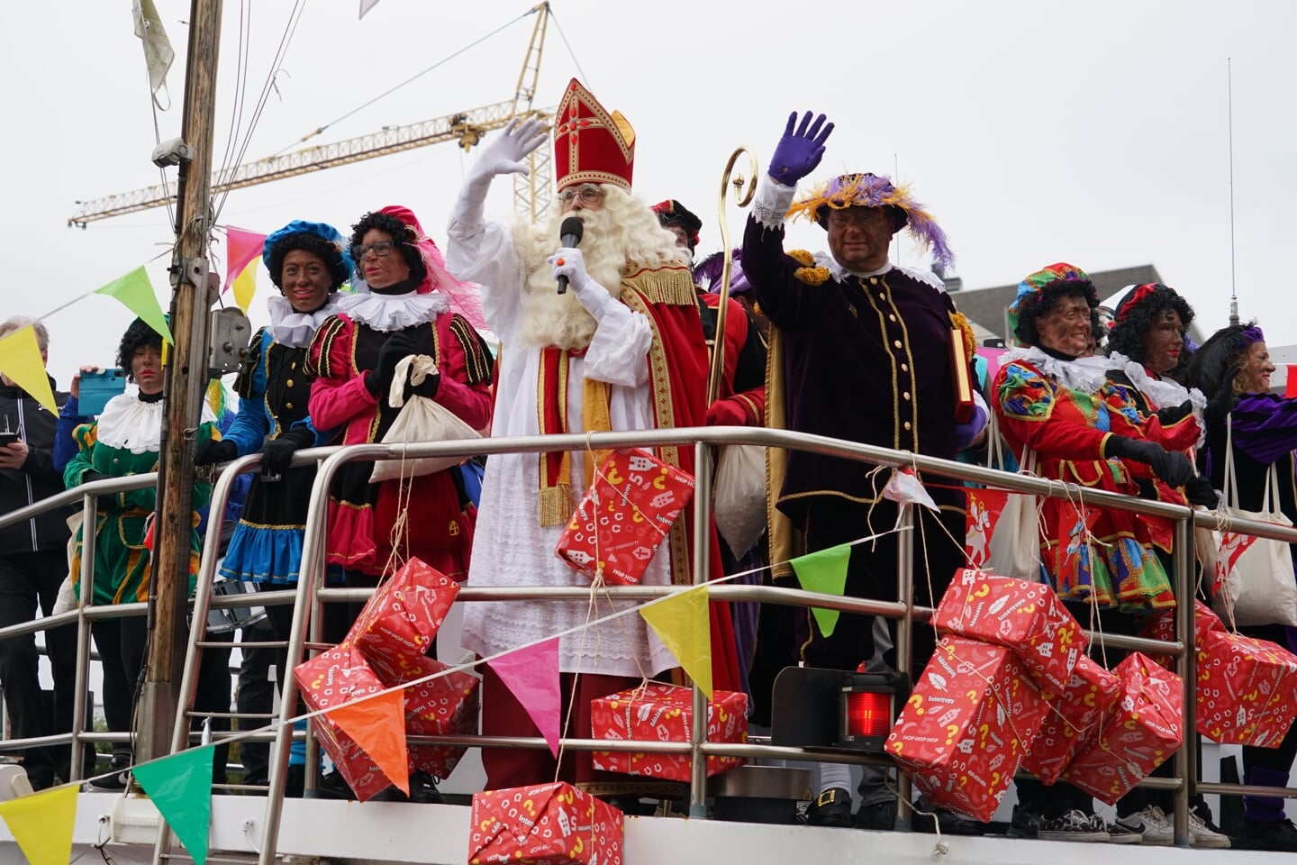 Sinterklaas en zijn pieten zwaaien vanaf de boot naar de vele Leiderdorpertjes op de kade.