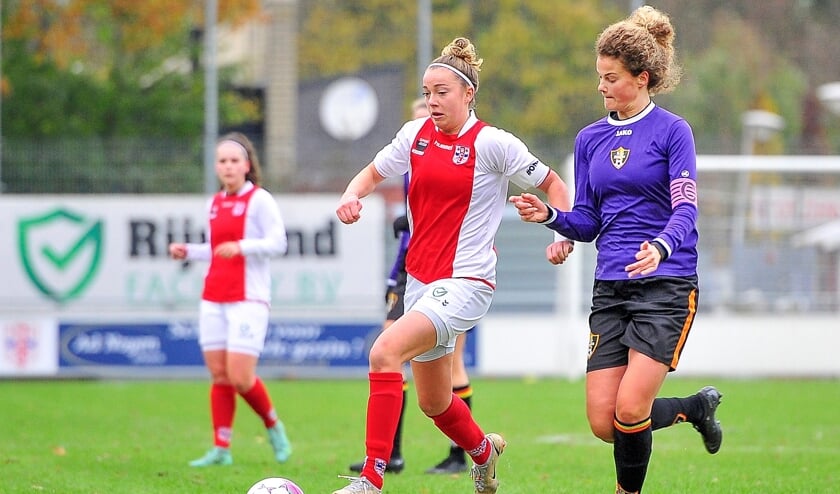 Racing aanvoerster Susanne Hoogenboom is Stiens aanvoerster Siebine Burggraaff voorbij maar haar inzet treft geen doel.