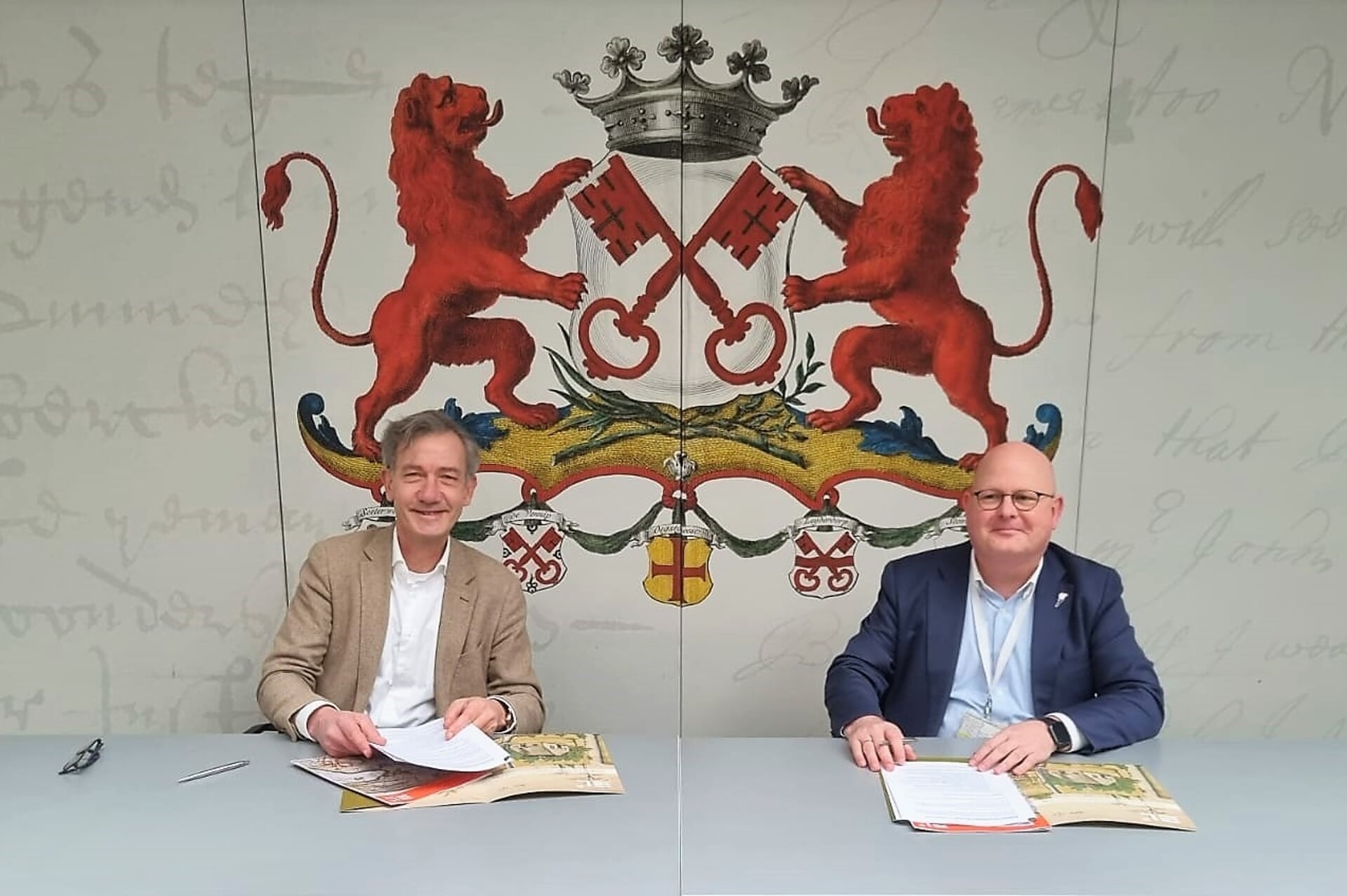 Ondertekening van de overdracht door wethouder Matthijs Huizing en Cor de Graaf van Erfgoed Leiden en omstreken.