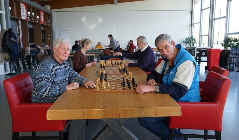 Herman Guis (links) en Thomas Stolker achter één van de schaakborden die Guis doneerde aan Clubhuis de Derde helft.   