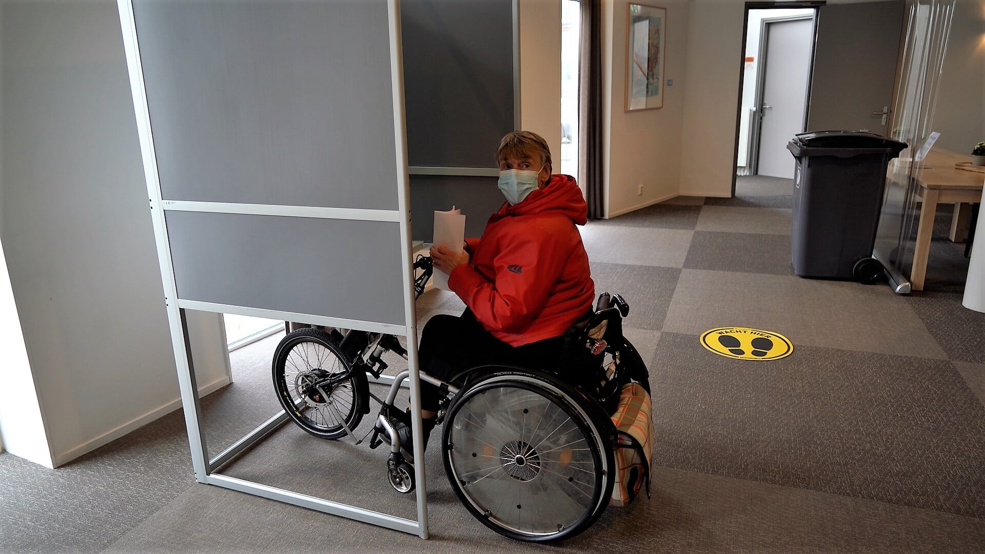 Truus Gerse test het stemlokaal op toegankelijkheid voor rolstoelen. | Foto: Marc Wonnink