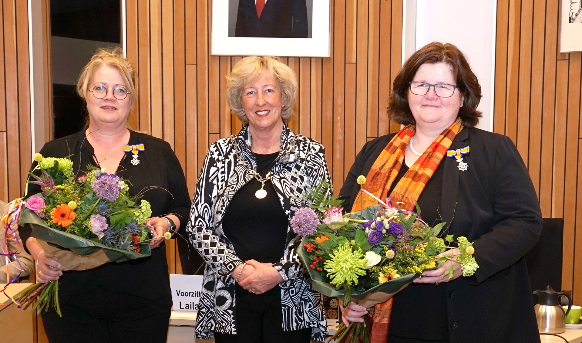 Burgemeester Driessen geflankeerd door de twee gedecoreerden, links Joyce van Reijn en rechts Jeannette Hofman-Züter.