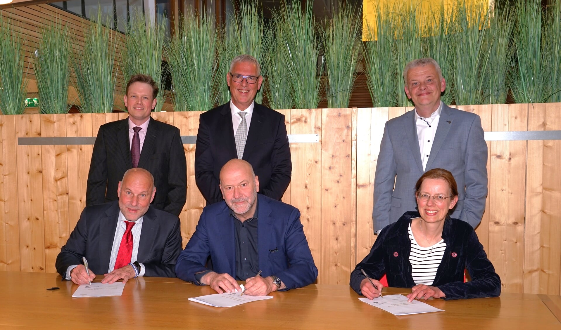 De fractievoorzitters van de coalitiepartijen ondertekenen het coalitieakkoord, de beoogde wethouders - die enkele uren later officieel benoemd werden - staan achter hen. V.l.n.r. Olaf McDaniel en Bob Vastenhoud van PvdA-GroenLinks, Hugo Langenberg en Herman Romeijn van de LPL en Medea Hempen en Daan Binnendijk van het CDA. 