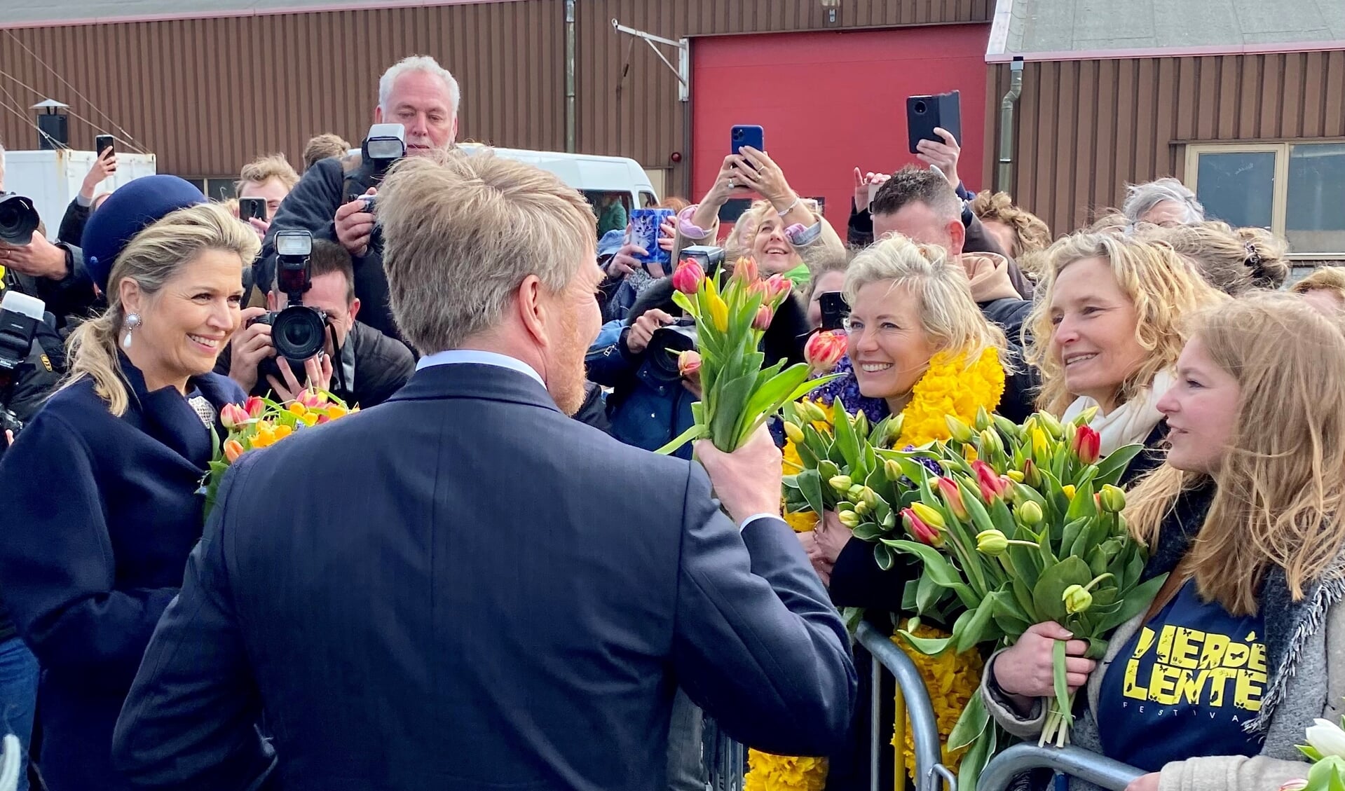 Koningin Máxima en Koning Prins-Willem Alexander krijgen tulpen van een van de festivalmedewerkers. | Foto: Caroline Spaans.