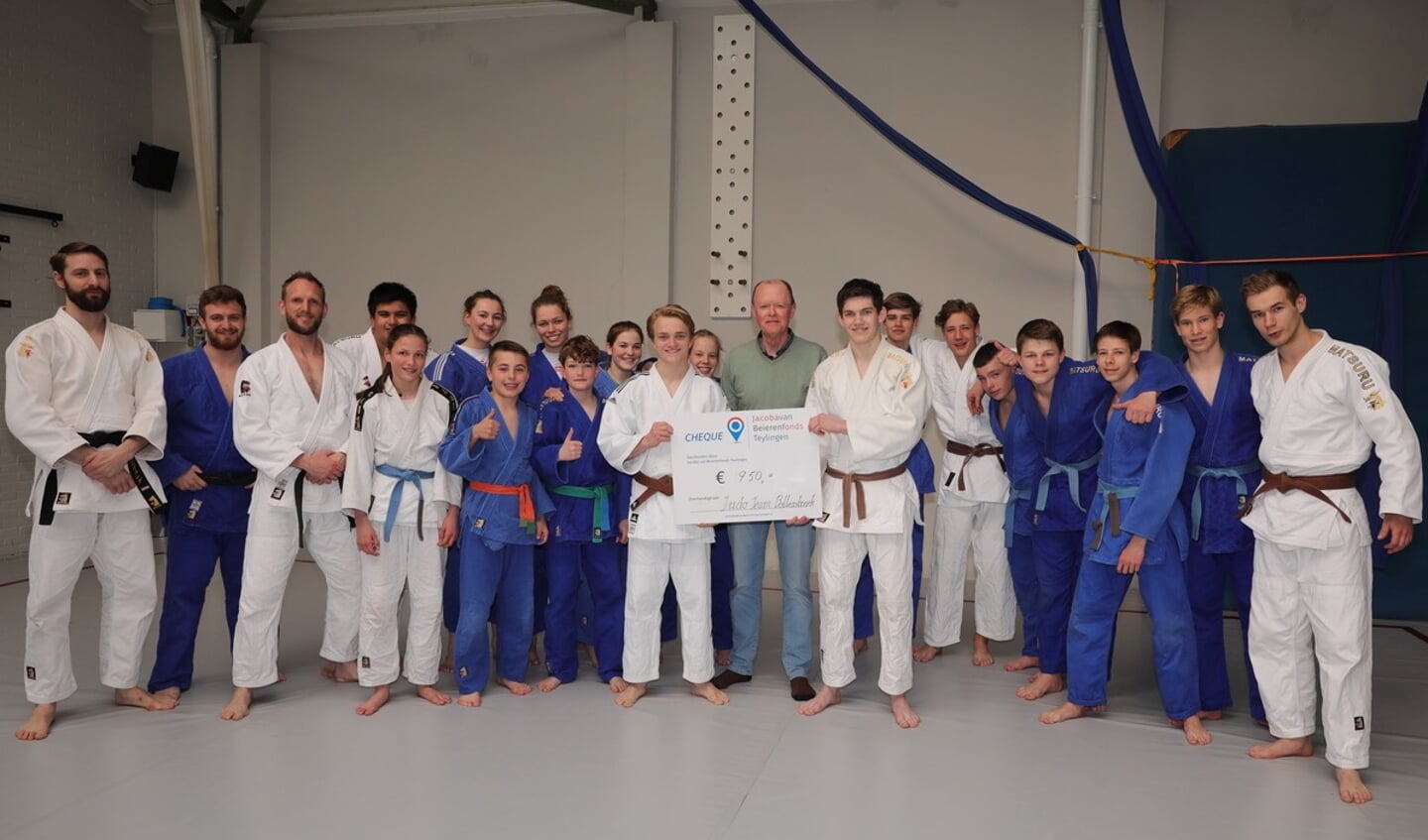 Voorzitter Frans Heemskerk (Jacoba van Beierenfonds) reikt de cheque uit aan de judoka's van Judo Team Bollenstreek. | Foto: pr.