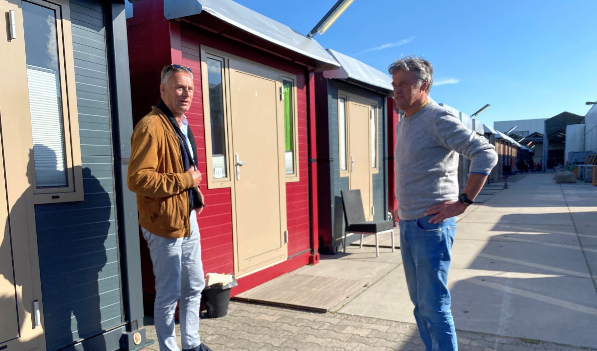 Wybe Kelderman (l) en Jos Mulders naast de cabines op het terrein van de Ruigrok Groep, waarin zij hun 'praktijk' hadden. | Foto: Caroline Spaans. 