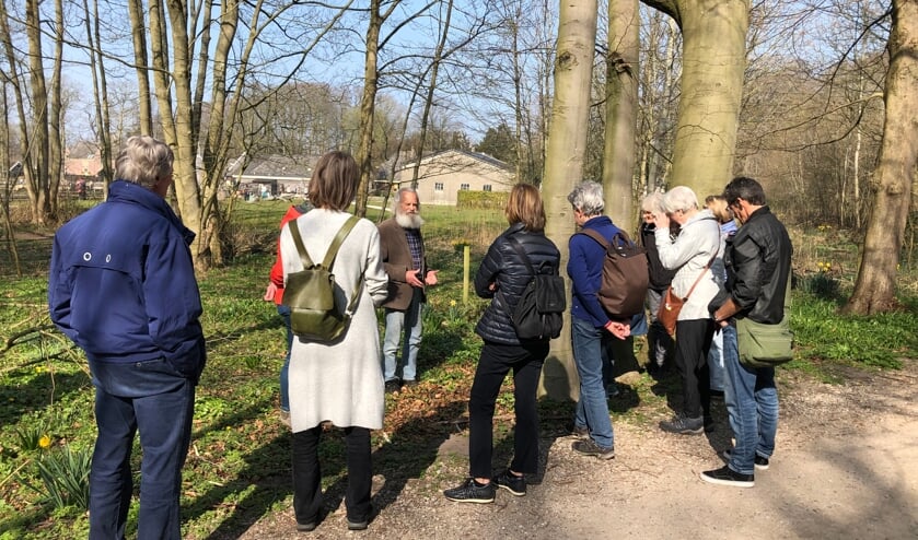 Gids Wim Grimme vertelt deelnemers over alles wat er groeit en bloeit in het Keukenhofbosch.