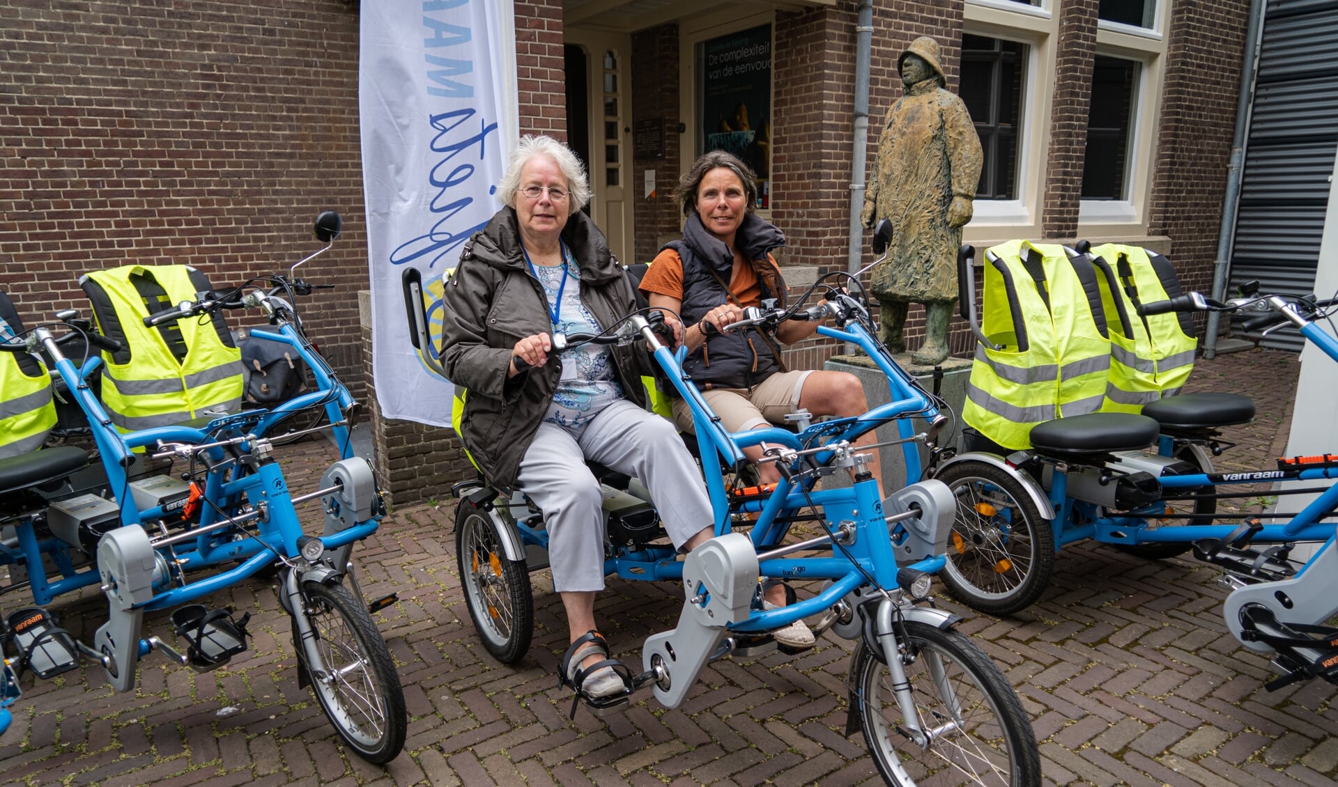 Wil en Carola voor het Katwijks Museum op de duofiets | foto: Marc Wonnink