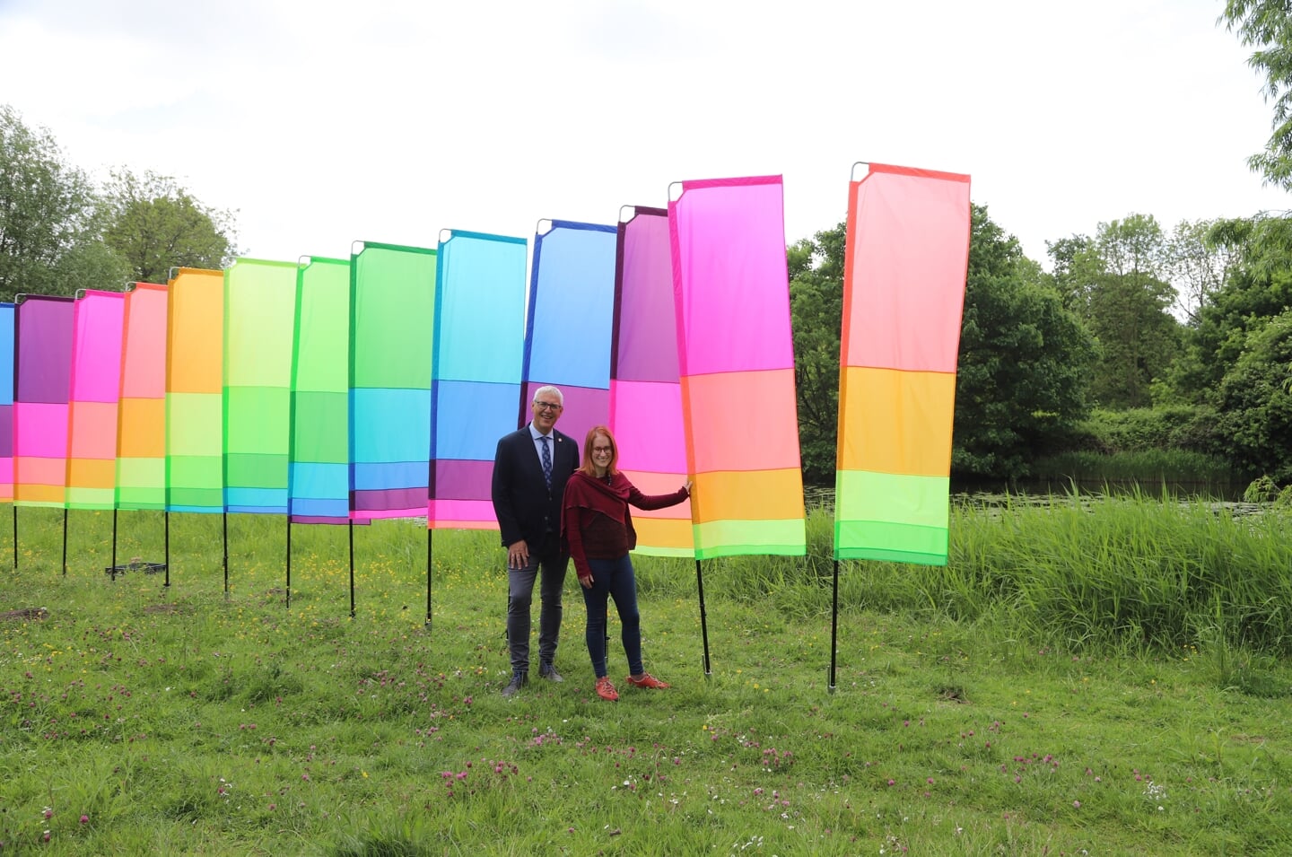 Cultuurwethouder Herman Romeijn en cultuurcoach Anne-Pauline van der A bij de kleurrijke vlaggen. | Foto: WH