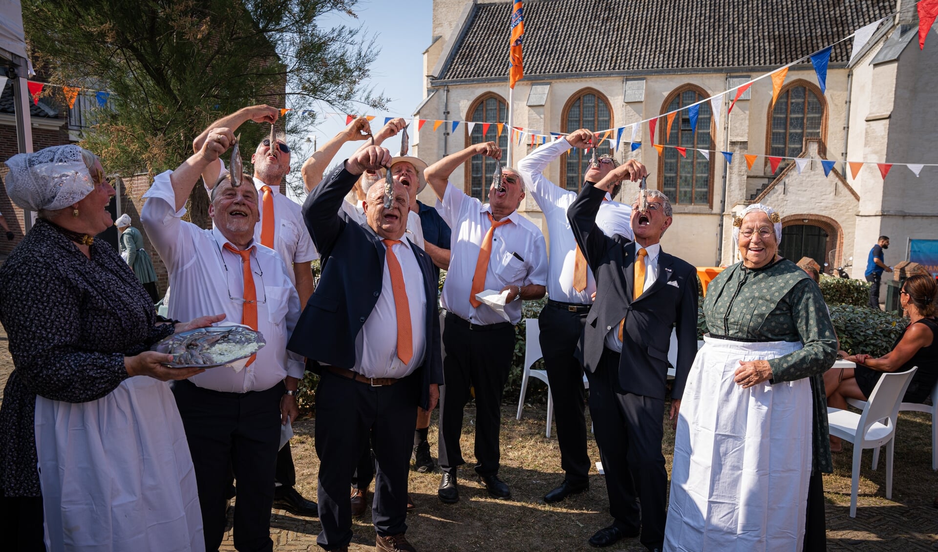 Het bestuur van de Oranjevereniging Katwijk aan Zee laat zich het zilver uit zee goed smaken. Foto: Marc Wonnink