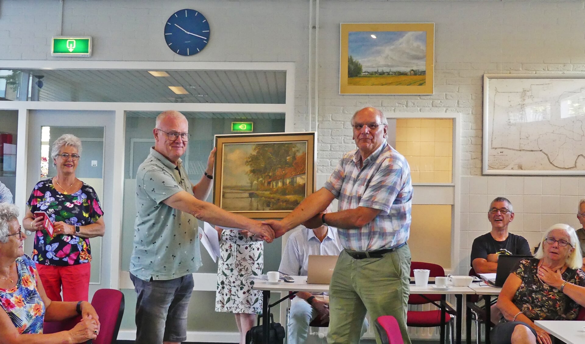 Gerard Mens overhandigt het schilderij van de hand van Casper Verlint aan SOS-voorzitter Alfred Pop.  