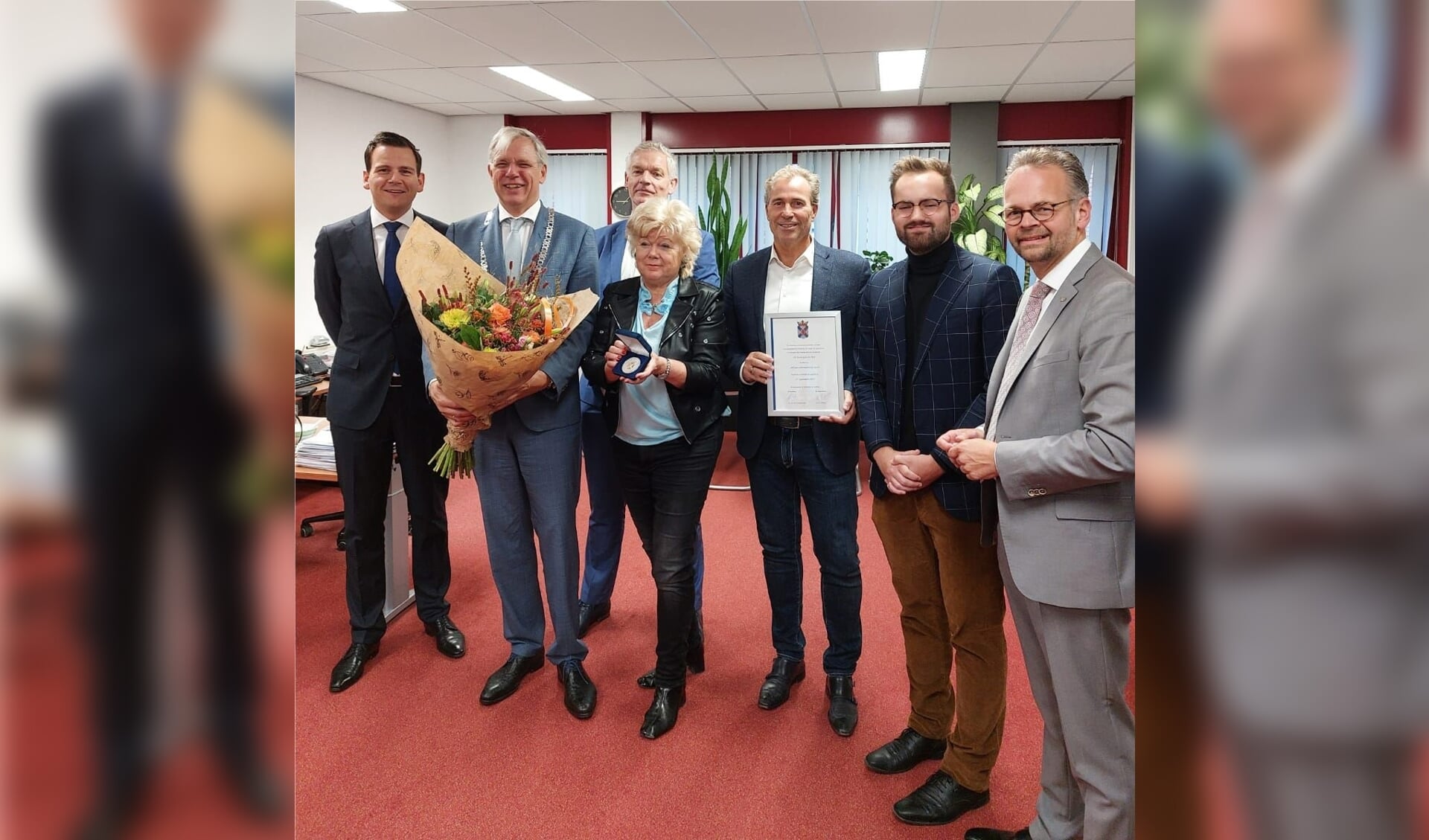 Burgemeester en wethouders van de gemeente Katwijk overhandigen de erepenning en oorkonde aan Dirk Bouman, directeur en Teuntje van Delft, hoofdredacteur. 