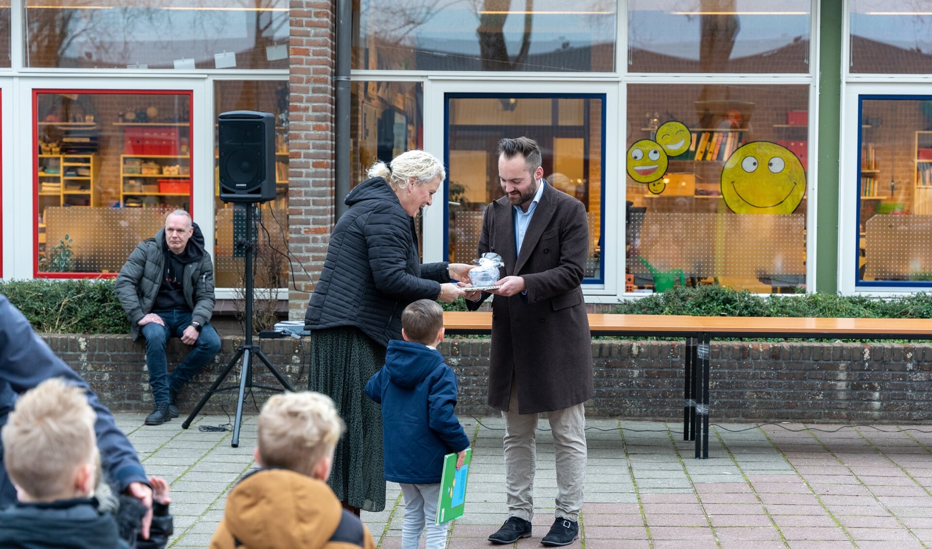 Wethouder Sonny Spek overhandigt een cadeau aan een van de lagere klassen van de Van der Bruggenschool. | Foto Marc Wonnink