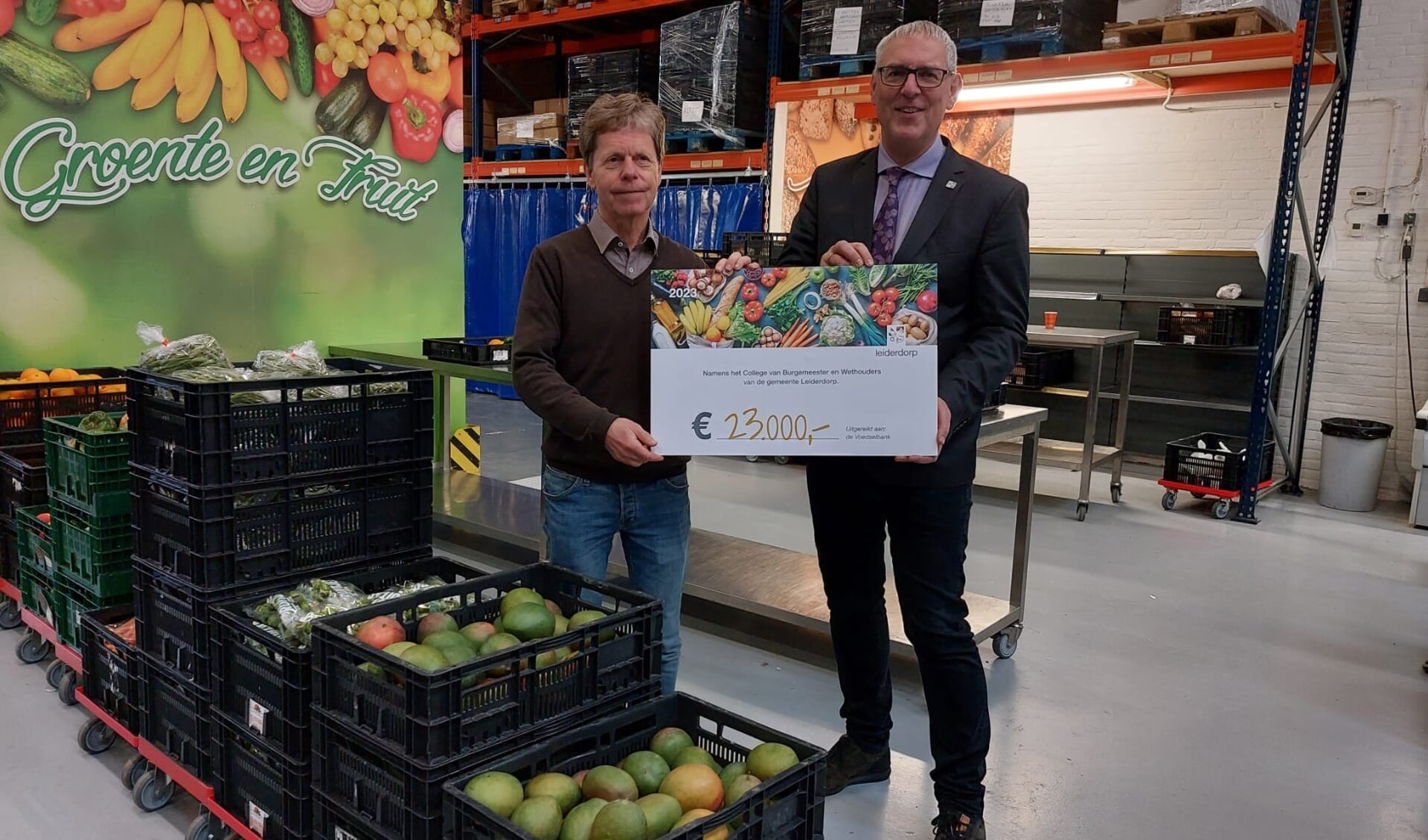 Wethouder Herman Romeijn (rechts) overhandigt de cheque aan bestuursvoorzitter Frank Mittertreiner van de Stichting Voedselbank Leiden e.o.