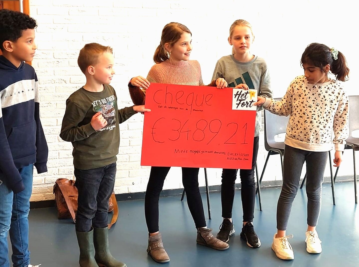Kinderen van basisschool De Bron tonen trots hoeveel geld voor 'het Fort' ze bij elkaar gelopen hebben. | Foto: PR