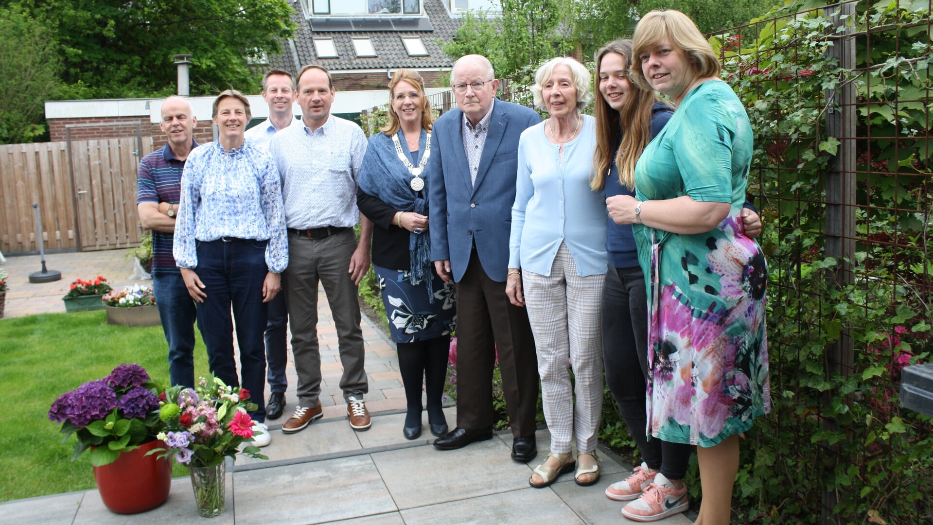 Het echtpaar Sassen met burgemeester Carla Breuer en familieleden in de tuin.
