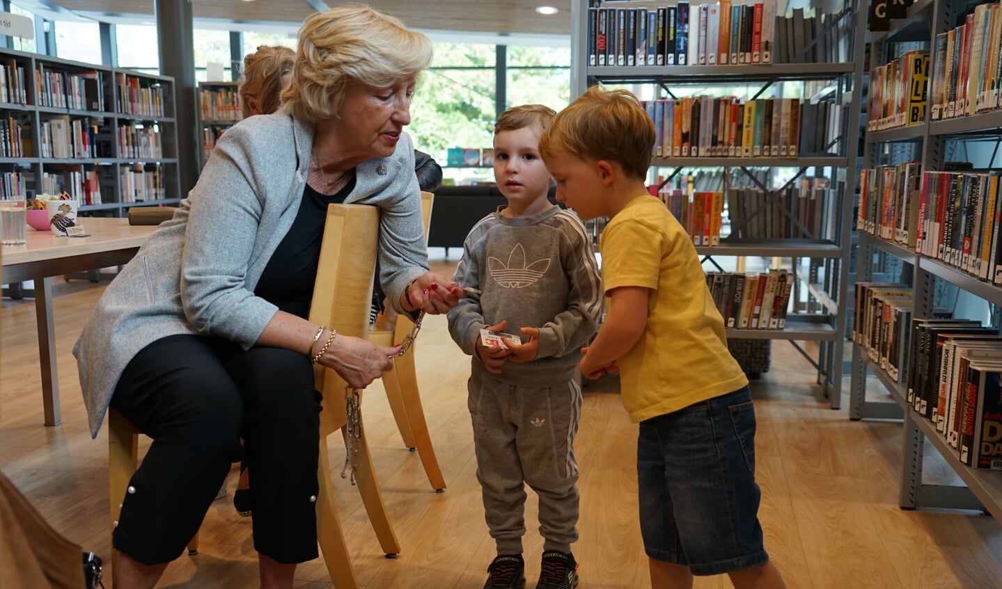 Burgemeester Laila Driessen laat Matthijs en David haar ambtsketen zien.