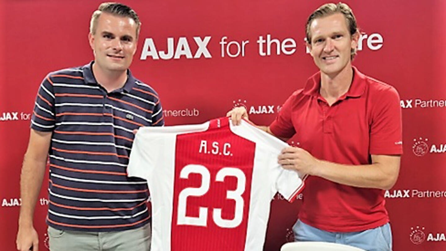 Hoofd Jeugdopleiding Cor Stols (Ajax) en jeugdvoorzitter Julius Janssen van ASC tonen trots het shirt dat Ajax bij het tekenen aan het Oegstgeester Ajax heeft geschonken.
