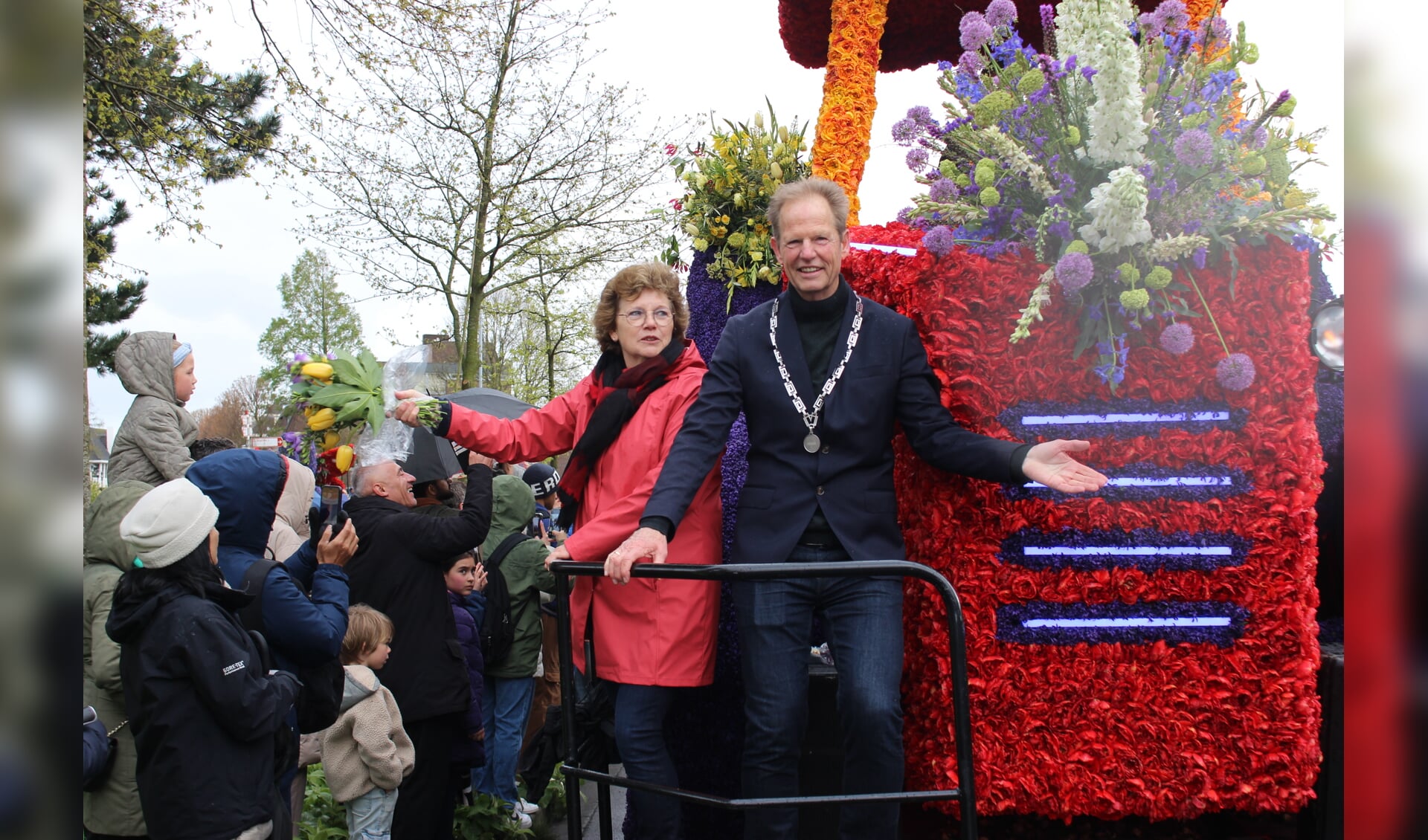 Burgemeester Arie van Erk en zijn vrouw reden mee op de wagen van gemeente Hillegom. | Foto: Annemiek Cornelissen