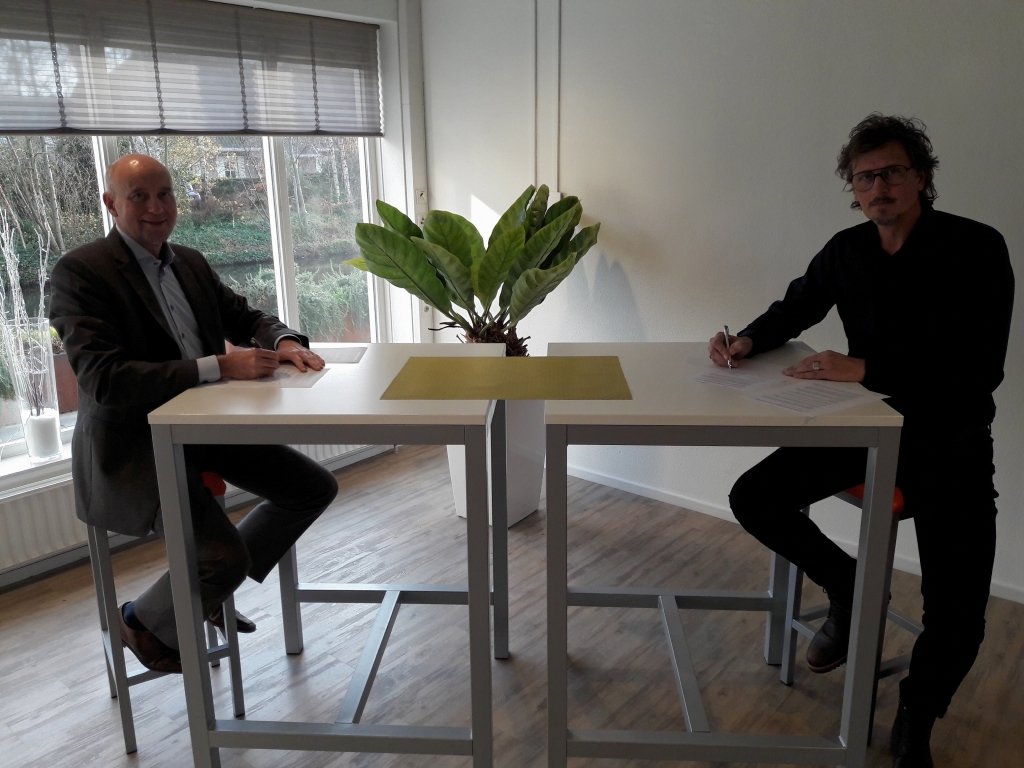 Wethouder Arno van Kempen en voorzitter Rob Batenburg ondertekenen de overeenkomst voor samenwerking tussen gemeente en Sportraad.