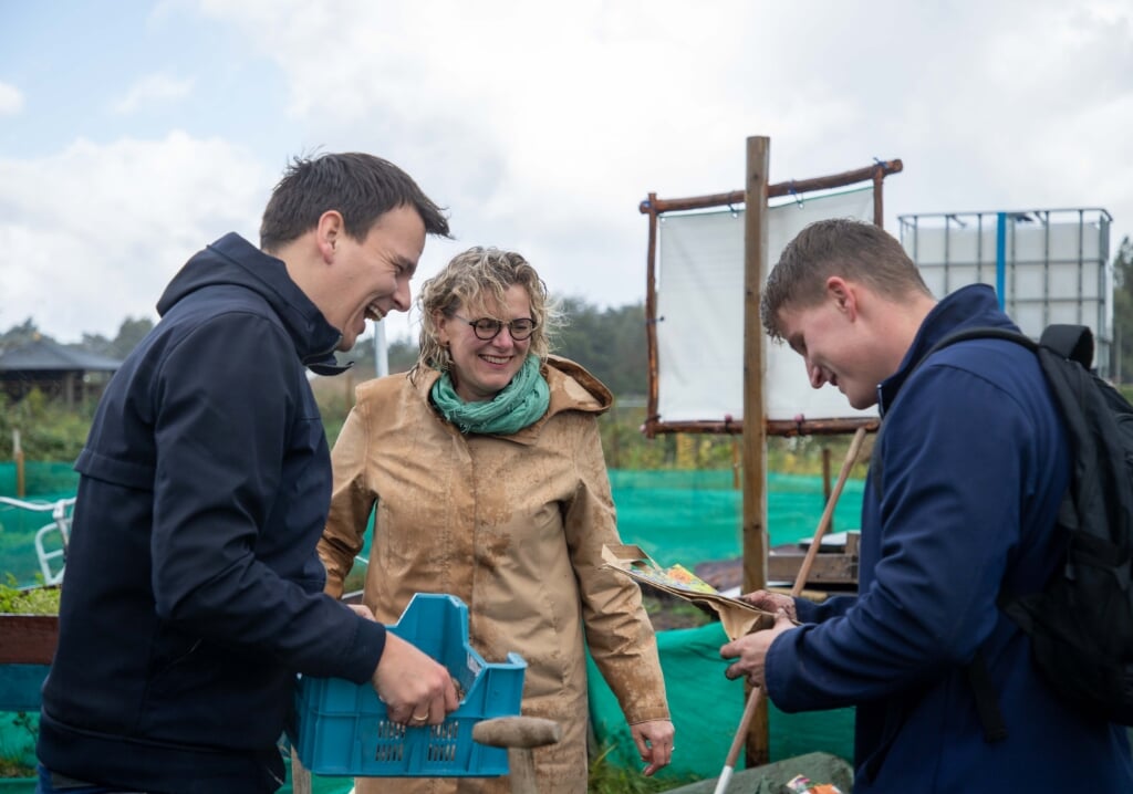 Wethouders Gerard Mostert en Corien Starkenburg helpen een handje in de moestuin Hortus Kariva. | Foto: pr