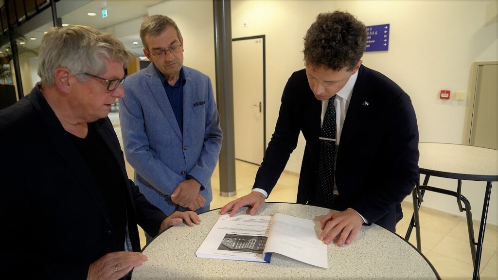 Adri van Beelen (links) en Leendert de Vink overhandigen de petitie voor behoud van de Opleidingsschool aan commissievoorzitter Berend Tensen (rechts). | Foto: Marc Wonnink