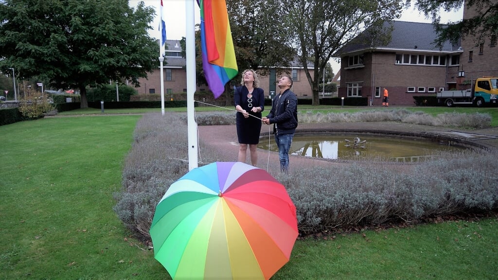 Wethouder Corien van Starkenburg hijst samen met turner Jeffrey Wammes de regenboogvlag. | Foto: Marc Wonnink