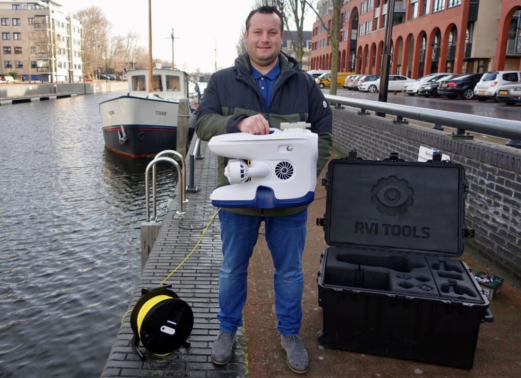 Rutger van Duijn test een nieuwe onderwaterdrone in de Prins Hendrikkade. | Foto: Aad van Duijn