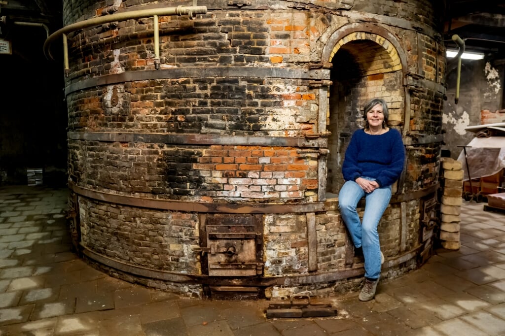Jolanda Ginjaar bij de grote oven waar een eeuw lang de kleiproducten gebakken werden. 