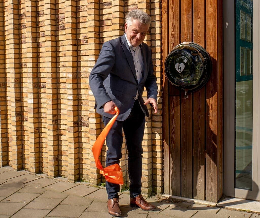 Wethouder Daan Binnendijk heeft net de AED bij basisschool De Leeuwerik onthuld. | Foto: J.P. Kranenburg 