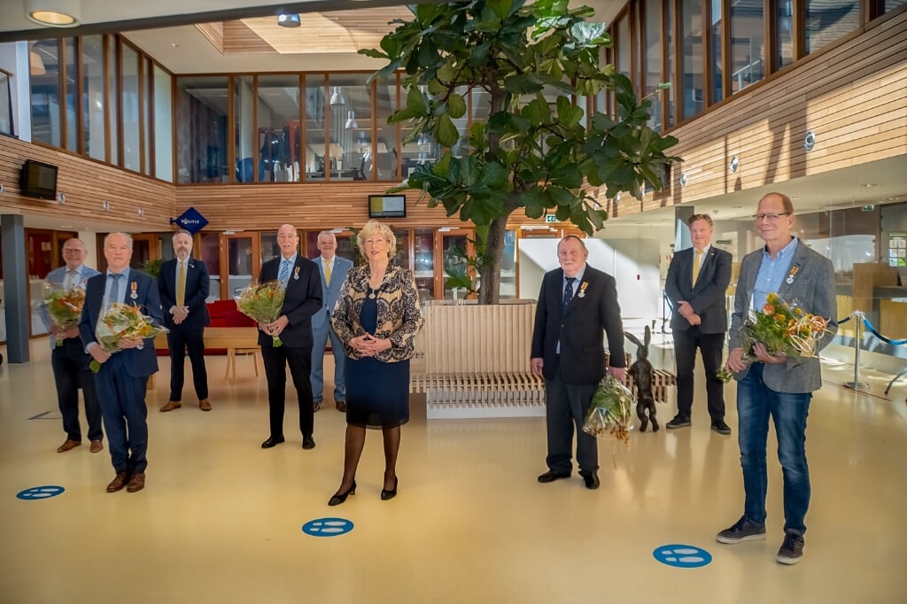 De gedecoreerden (met bloemen) en het Leiderdorpse college van B en W. V.l.n.r. Gerrit Anker, Rob Snoep, wethouder Willem Joosten, Jos van der Lubbe, wethouder Daan Binnendijk, burgemeester Laila Driessen, Willem Molenaar, wethouder Rik van Woudenberg en Ed Weijdeveld. | Foto: J.P. Kranenburg