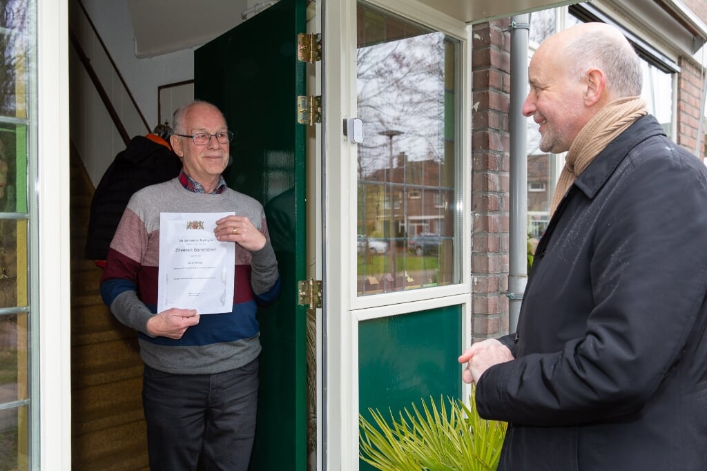 Wim Prins krijgt de Zilveren Barensteel thuis overhandigd door wethouder Arno van Kempen. | Foto: pr./Edwin van der Wijngaard