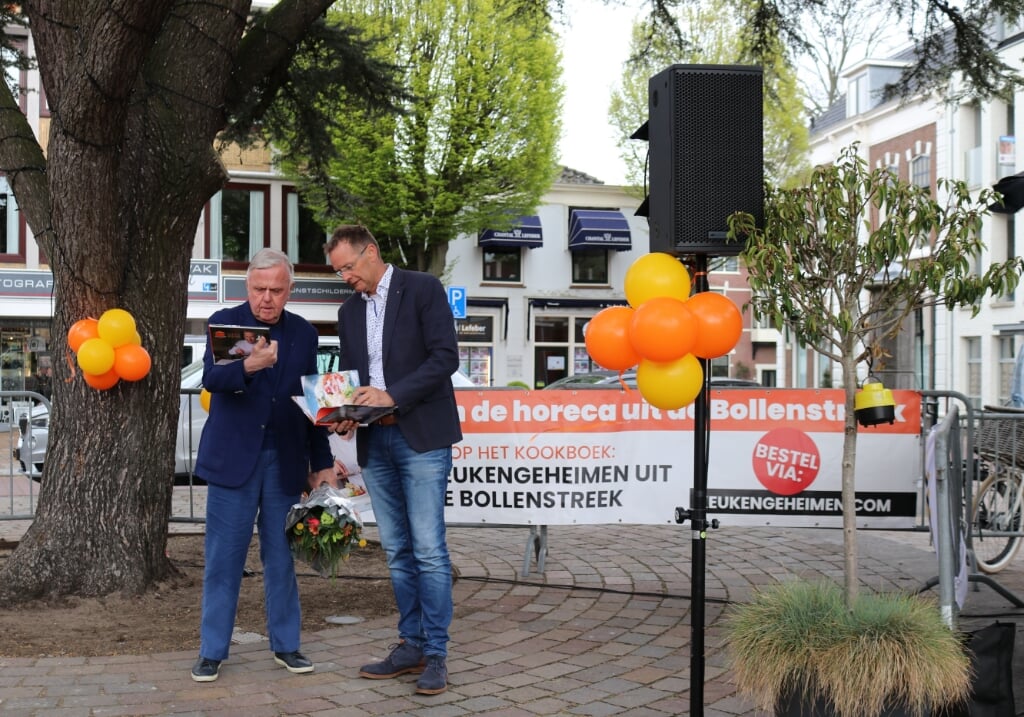 Harry Mens krijgt het eerste exemplaar uit handen van Rotary-lid Kees Hogervorst.