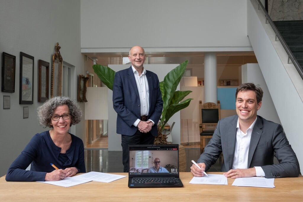 Wethouders Marlies Volten en Arno van Kempen (staand) ondertekenen de overeenkomst met ontwikkelmanager Stefan van Vliet (rechts). Ontwikkelaar Ewoud Swaak is digitaal aanwezig. | Foto: pr.