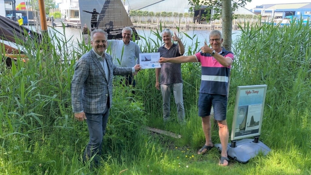 De vrijwilligers van de Hylke Tromp ontvangen een cheque van supermarkteigenaar van Hans Oudshoorn. | Foto: pr./Rosemarie Keijzer