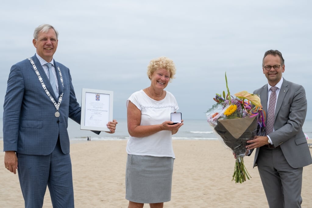 Blondi van der Woude met haar erepenning te midden van burgemeester Visser en wethouder Jacco Knape. | Foto: Rokki Fotografie