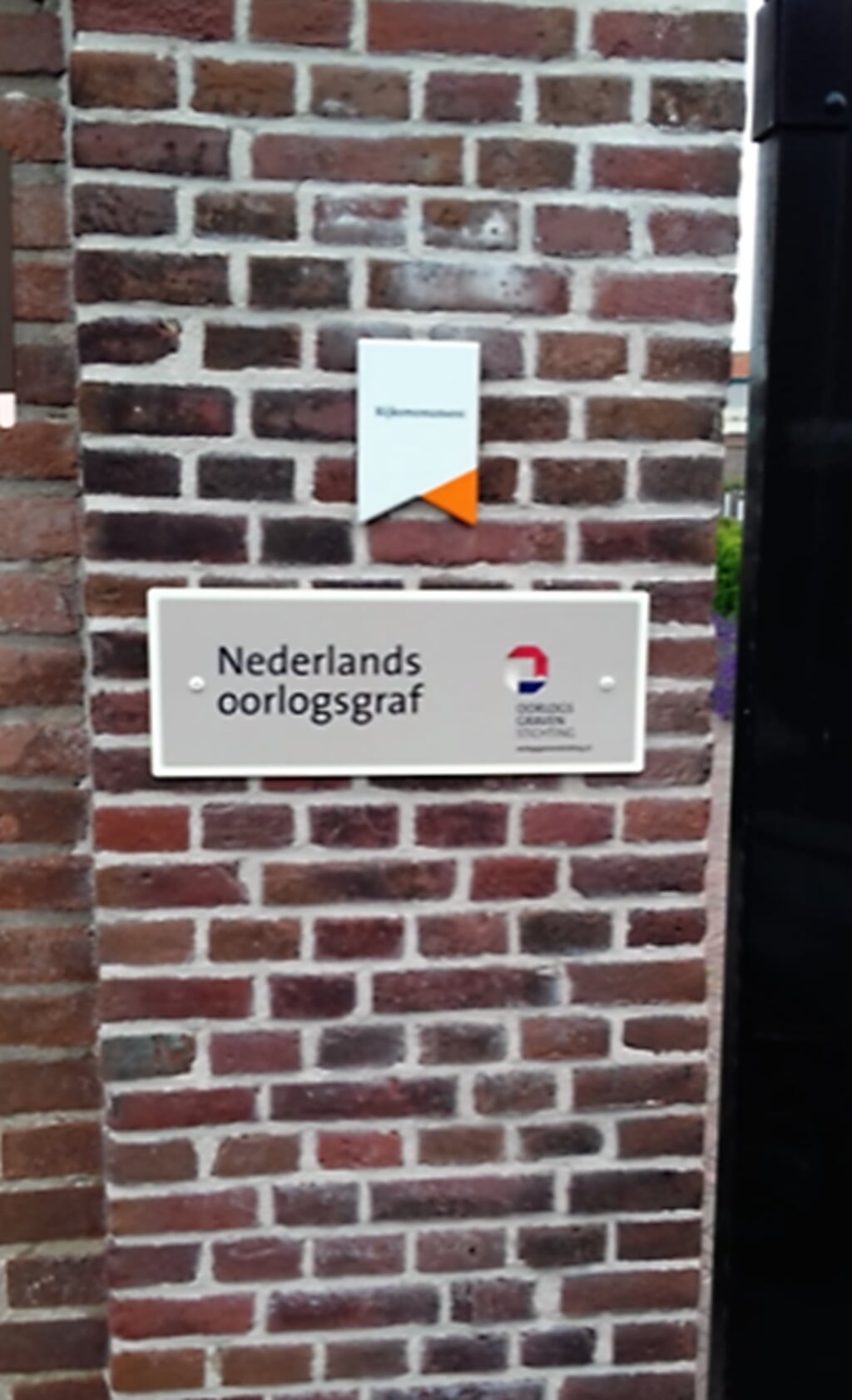 De vermelding ‘Nederlands Oorlogsgraf’ bij de ingang van de Oude Begraafplaats aan de Zuidstraat. 
