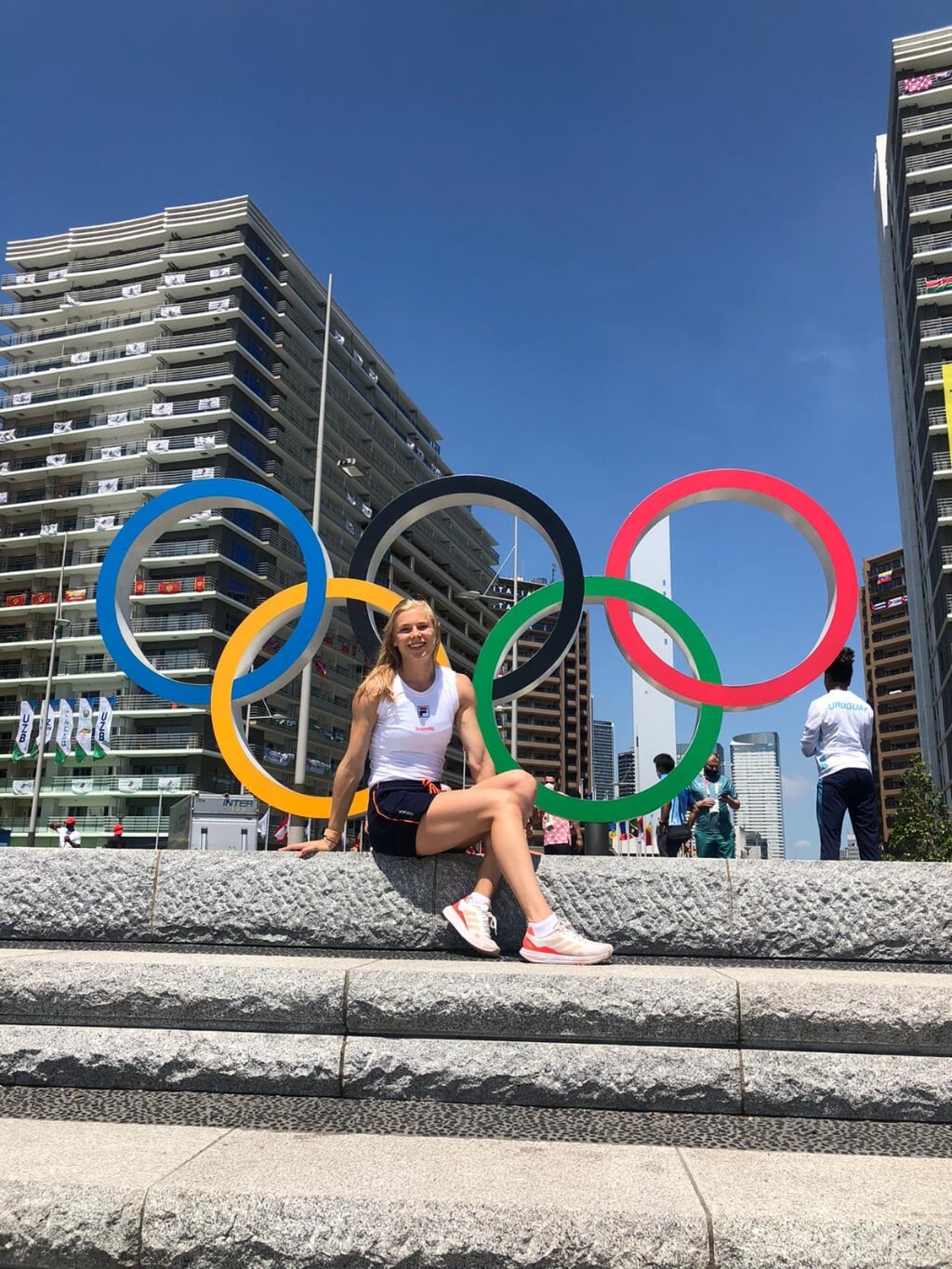 Andrea Bouma bij de iconische Olympische ringen in het sportersdorp. | Foto: pr.