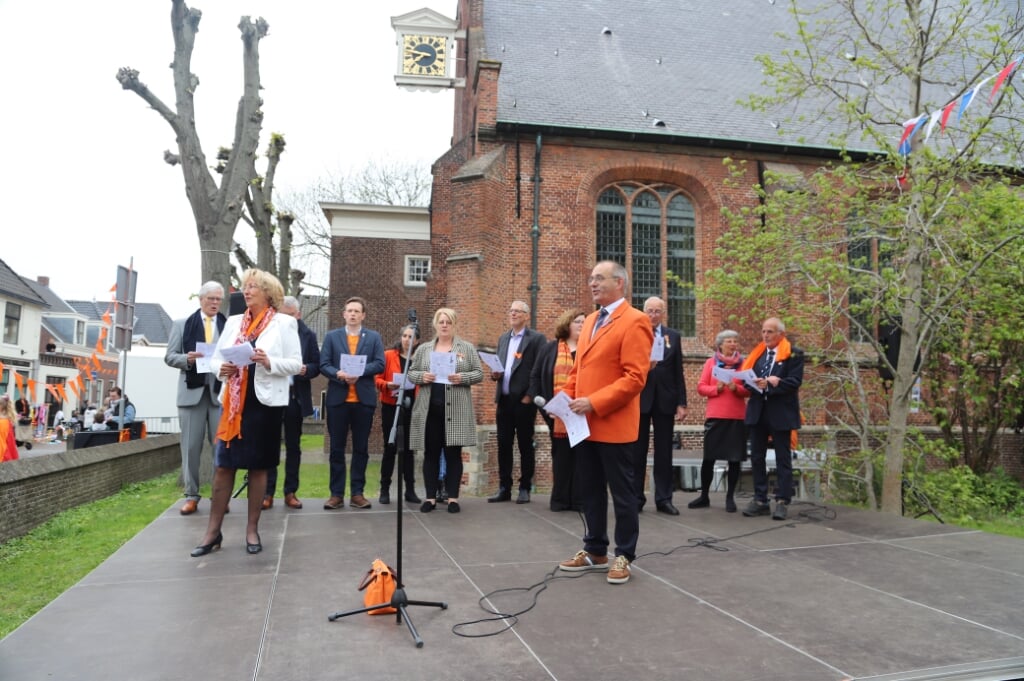 Burgemeester en wethouders, de gedecoreerden van het afgelopen jaar en voorzitter Hans Kruidenberg van de Oranjevereniging stonden om 9 uur 's ochtends al op het podium in de tuin van de Dorpskerk voor de aubade. | Foto: WH