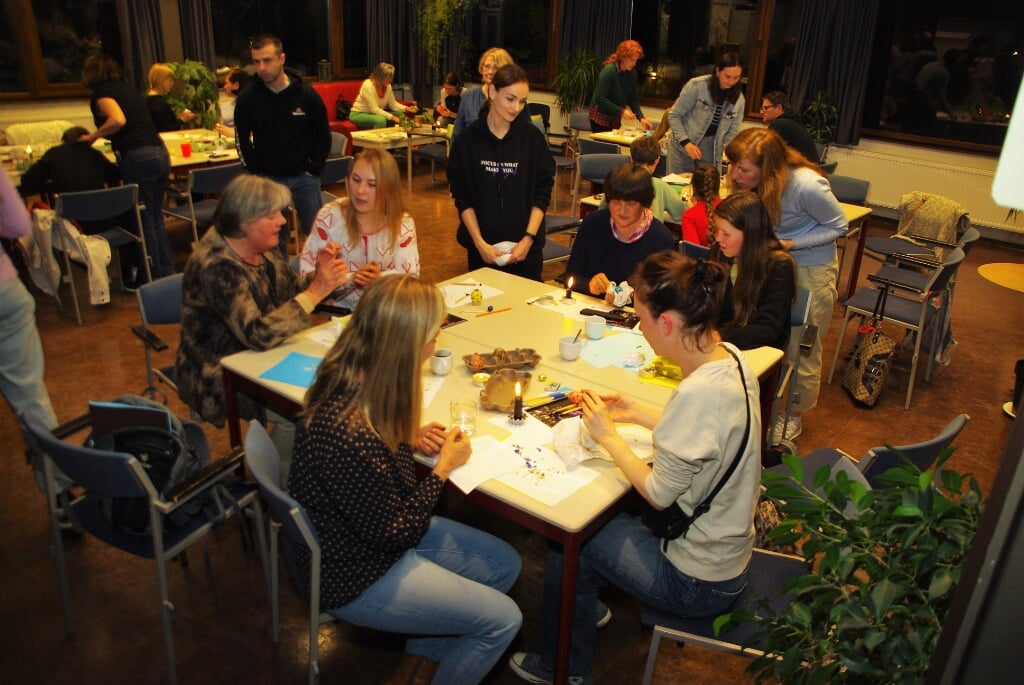 In de Bomenzaal van het Dorpscentrum ontmoetten Nederlanders en Oekraïners elkaar om samen op traditionele wijze paaseieren te versieren. | Foto Willemien Timmers