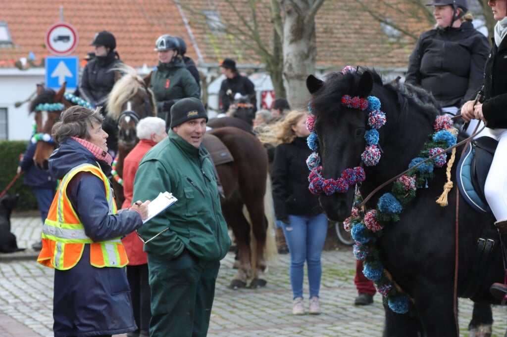Er lopen verschillende mensen met gele hesjes tussen de paarden door, dit zijn de juryleden die de paarden beoordelen