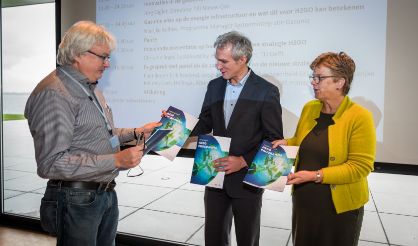 Chris Hellinga (TU Delft), schrijver van de strategie, overhandigt de strategie aan Tea Both van de gemeente Goeree-Overflakkee en gedeputeerde Berend Potjer van de provincie Zuid-Holland