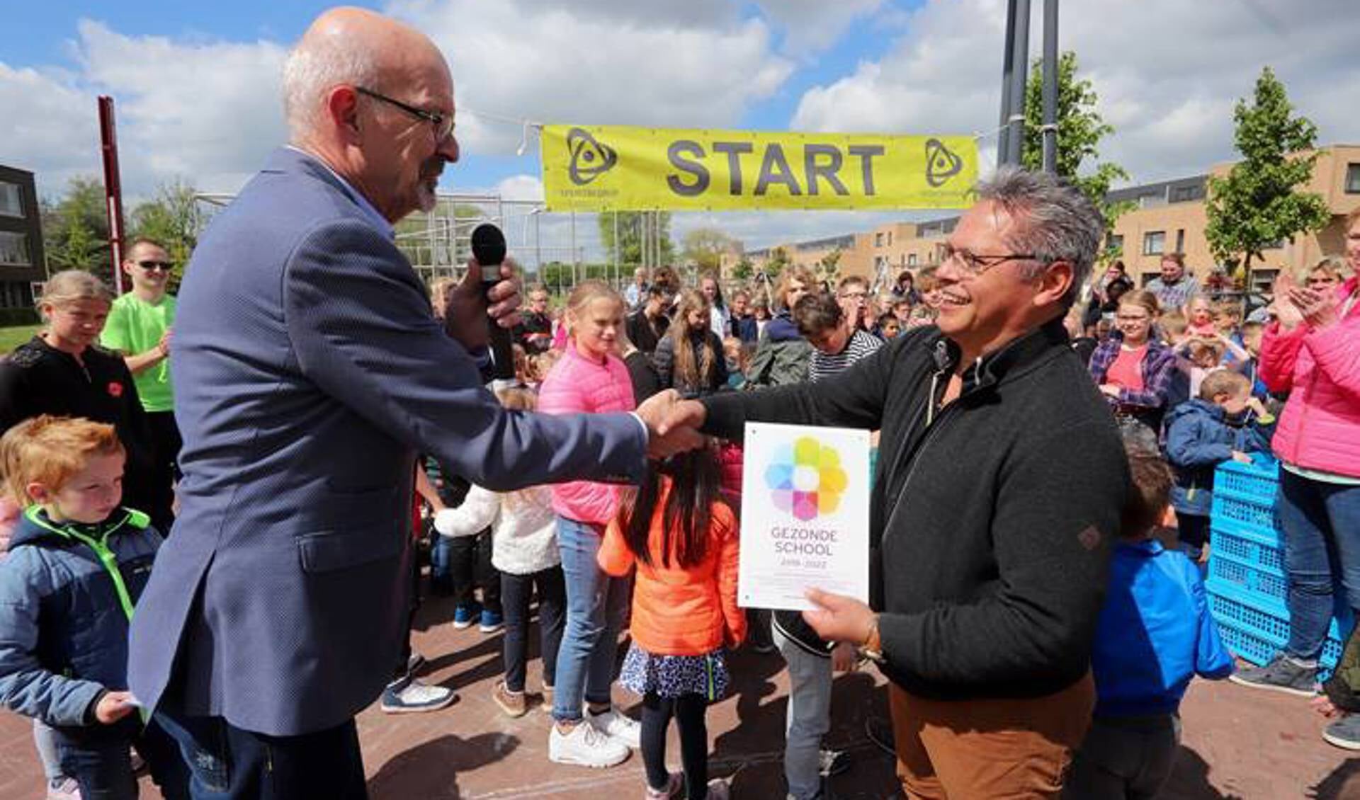 Wethouder Piet de Ruiter overhandigt het vignet Gezonde School aan Johan Vries, directeur van PCBO De Spreng